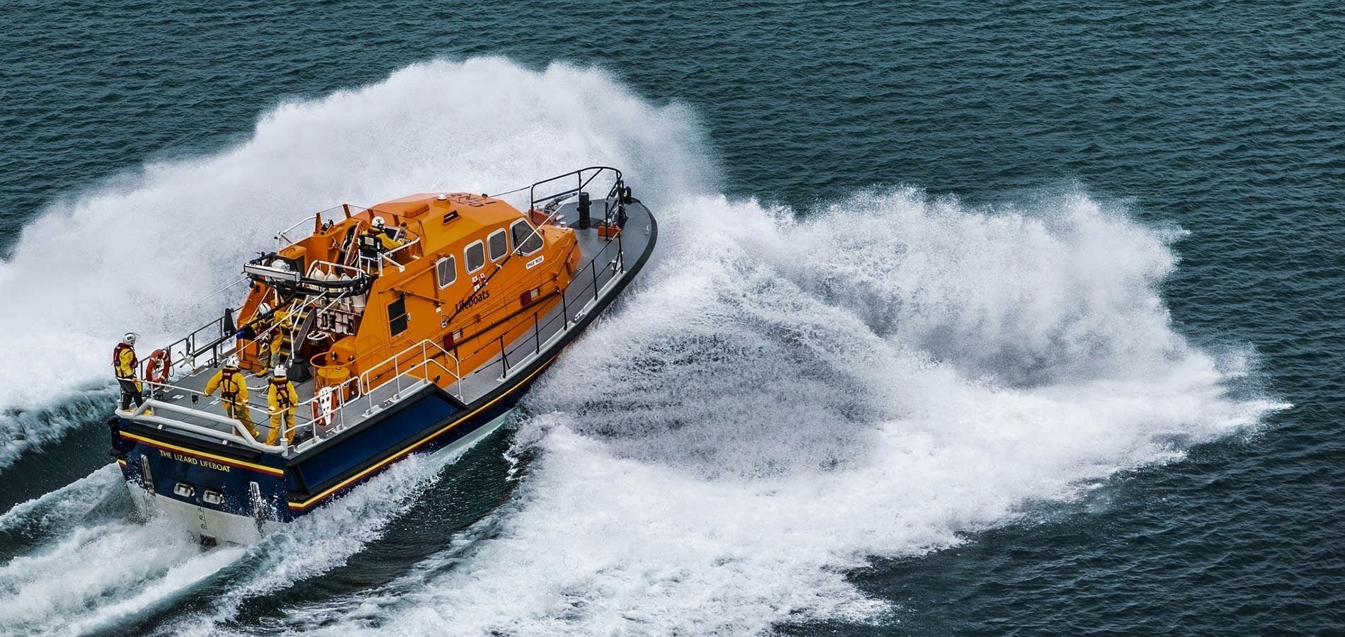 Royal National Lifeboat Institution lifeboat in action at sea, providing emergency rescue service.