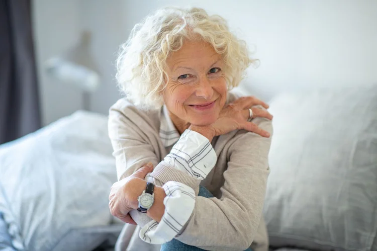 Confident mature woman with grey hair smiling, representing healthy ageing