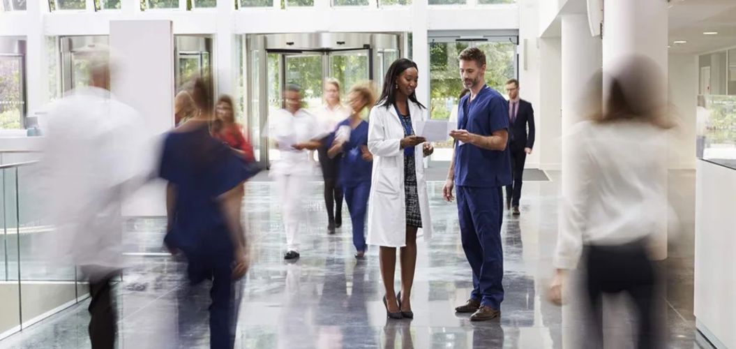 Two medical professionals standing in a hospital setting, representing healthcare teamwork.