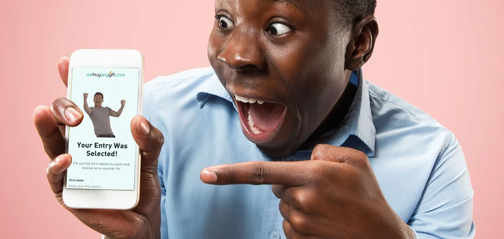 Man pointing at his smartphone with an excited expression, showing an app