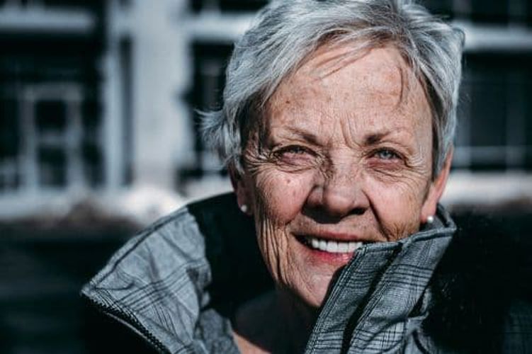 Smiling elderly woman looking at the camera in a warm and friendly portrait.