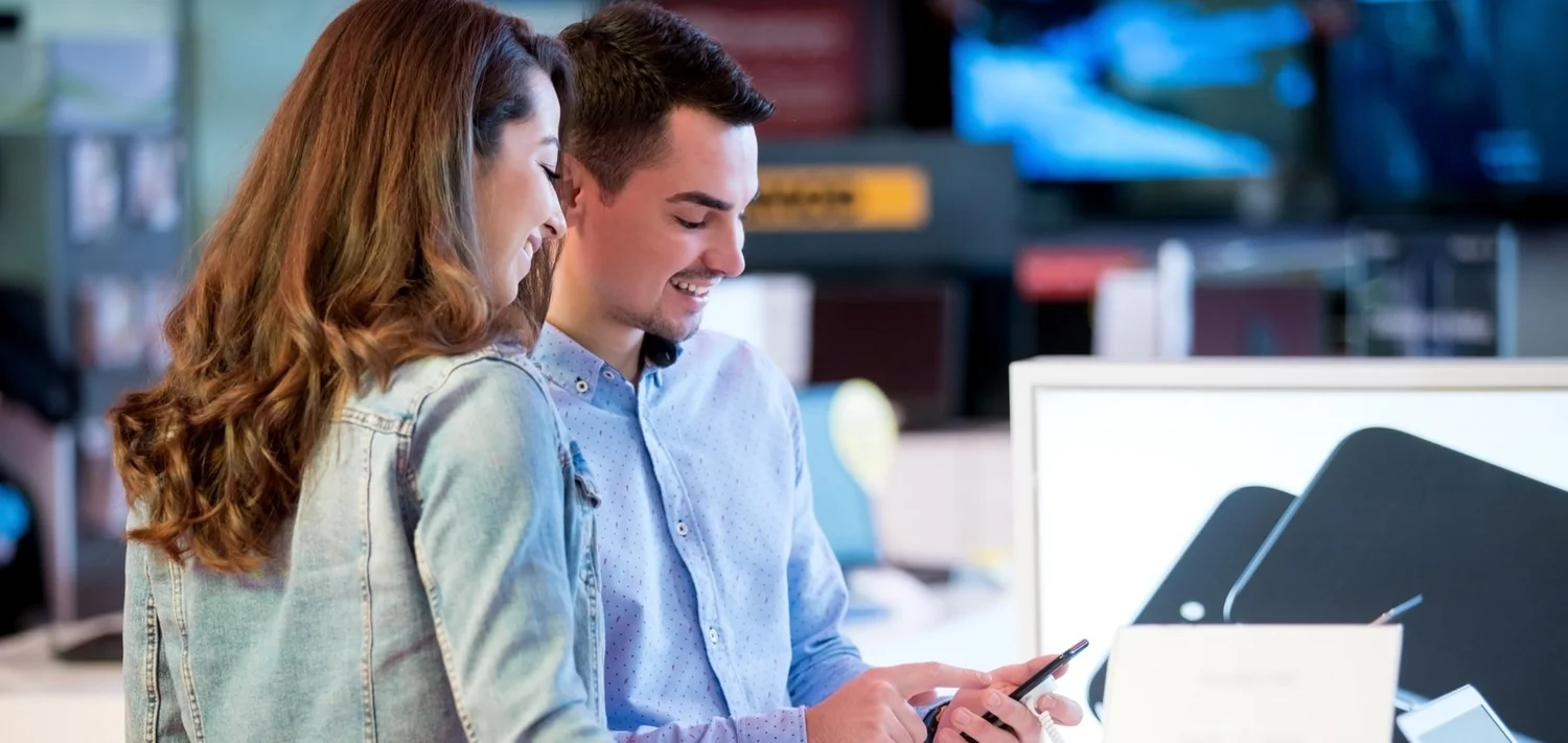 Customers browsing electronic products in a digital retail store environment.