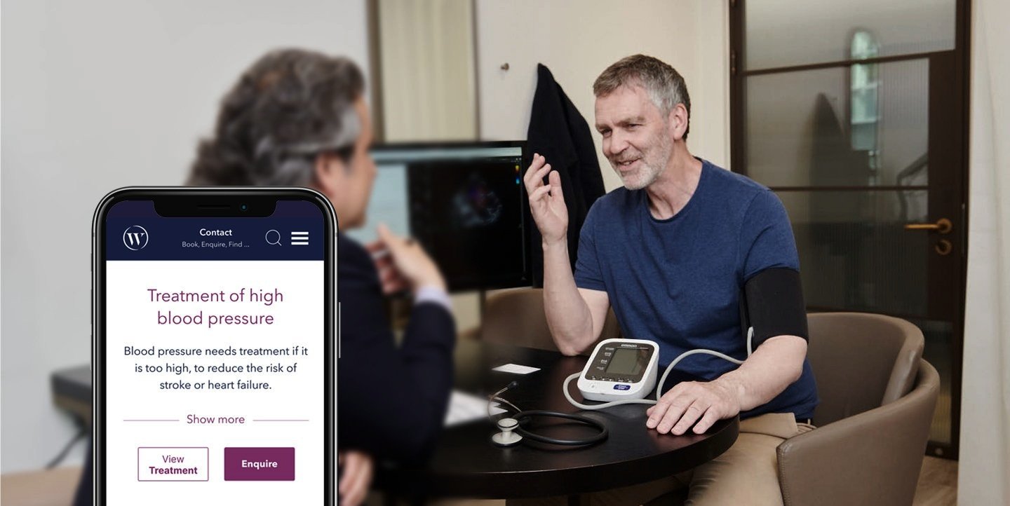 Client and consultants meeting with a mobile phone showing website design on screen.